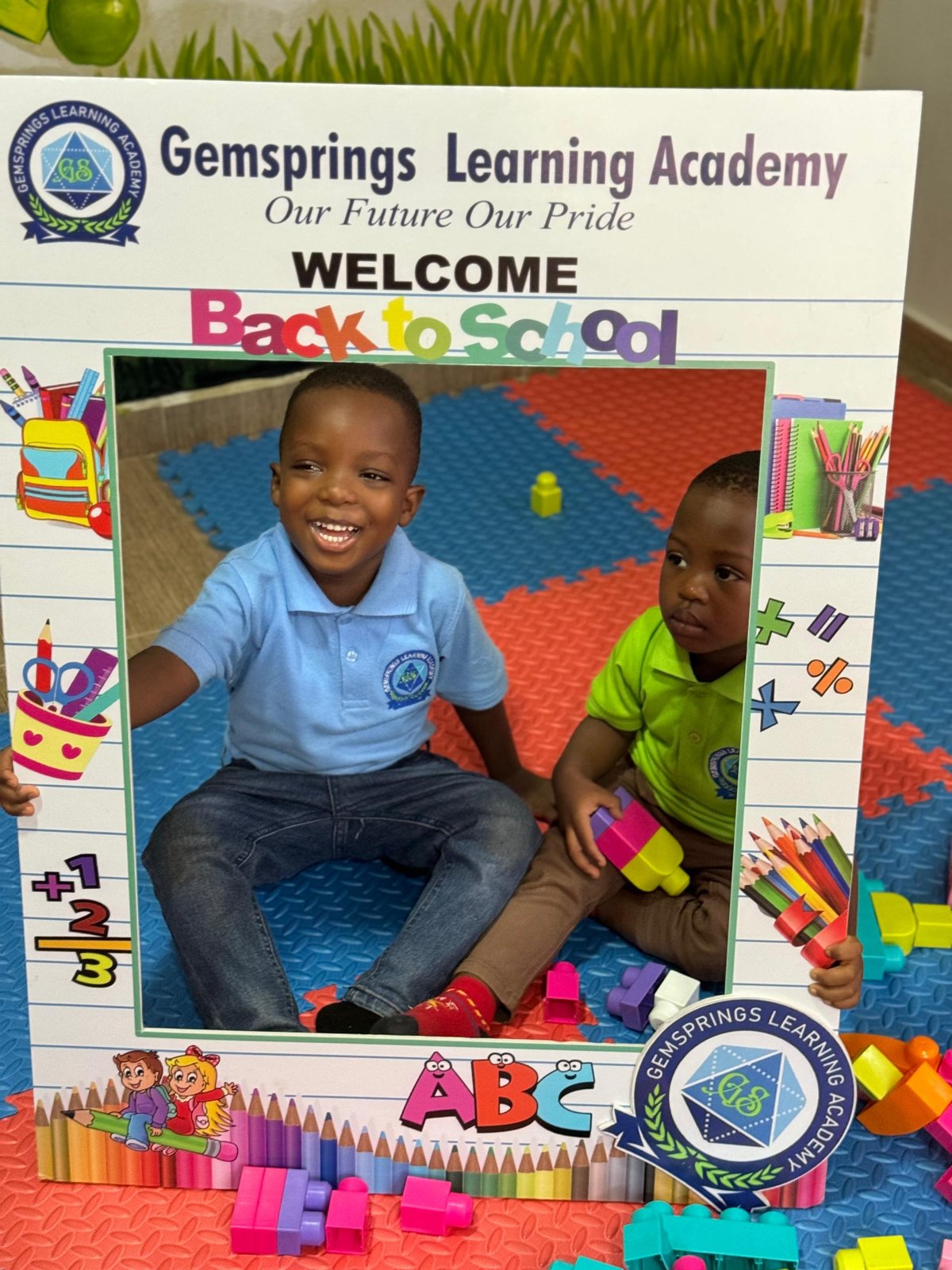 Children smiling inside a back-to-school photo frame