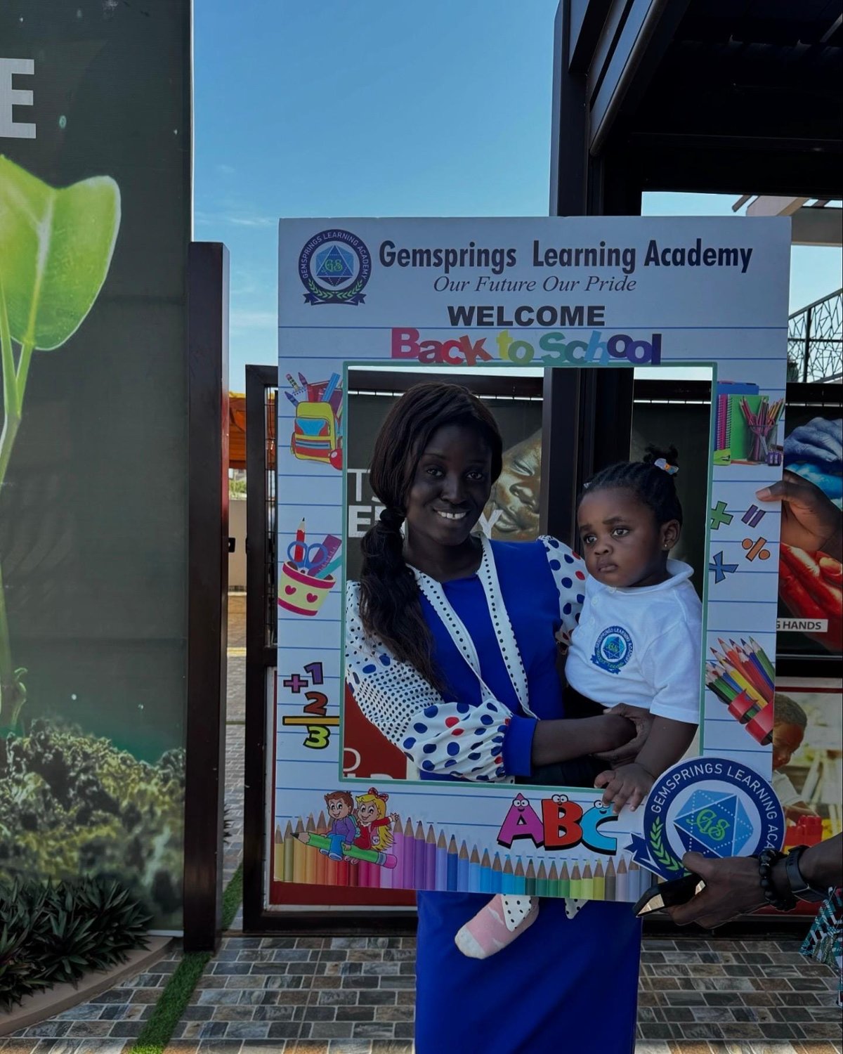 A parent and child posing at the Gemsprings welcome frame