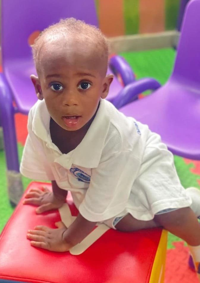 A toddler sitting on a small play chair
