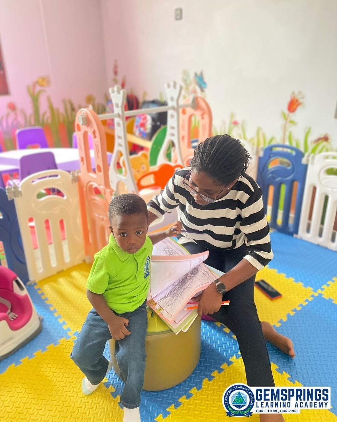 A pupil holding up her colourful paper weaving